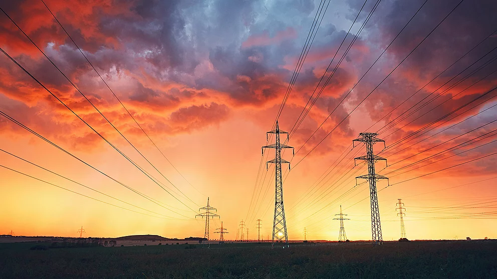 Strommasten vor einem dramatischen Sonnenuntergang